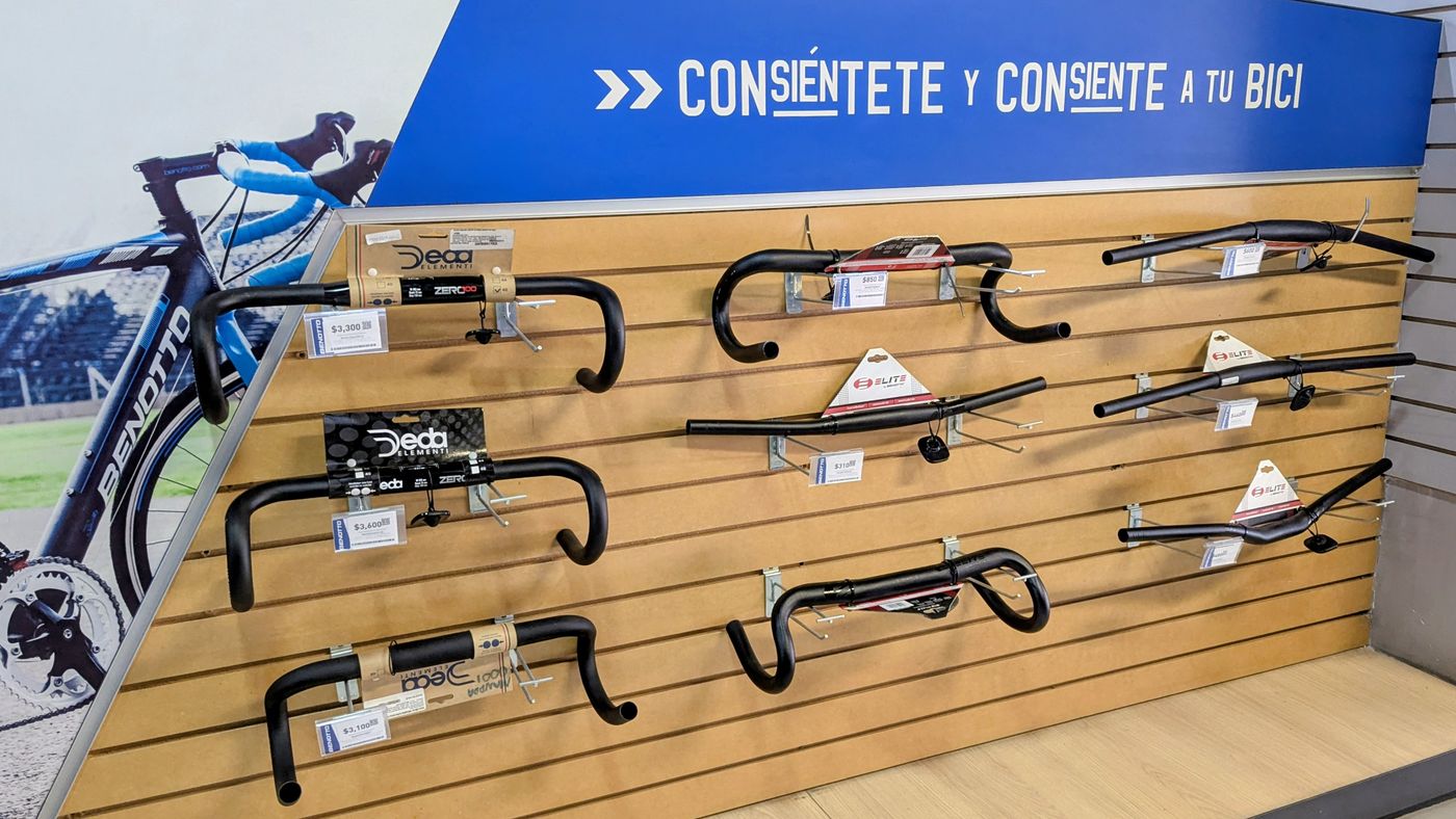 A store wall with the tagline Consiéntete y consiente a tu bici over handlebars