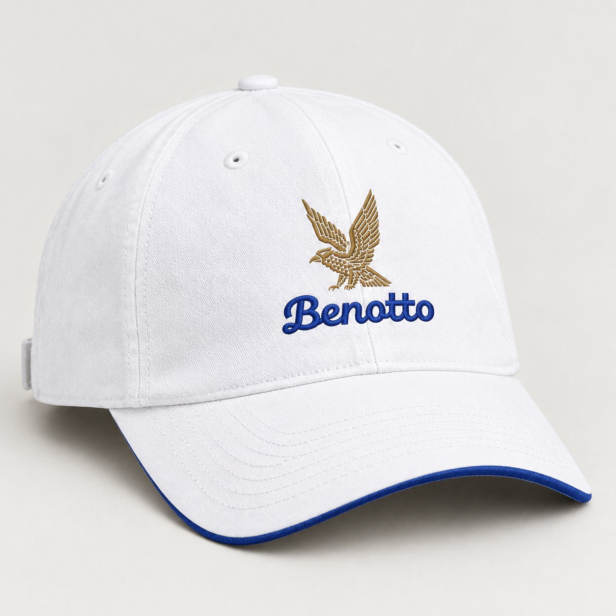 White cap with the gold eagle, the blue script wordmark and a blue brim edge