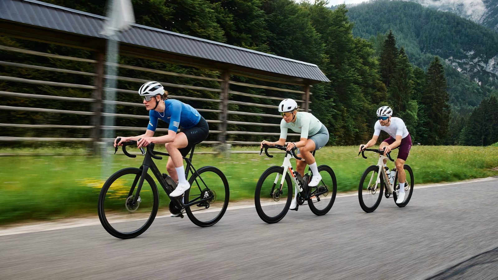 Three road cyclists at speed in black and white